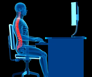 A demonstration of a person siting at a computer screen practicing good posture.