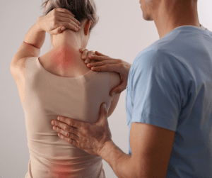 A woman seeing a professional about back care with her pain points indicated in red and the consultant placing his hands on her back 
