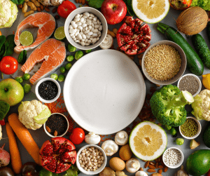 An image of healthy food surrounding a plat to demonstrate maintaining a balanced diet. 